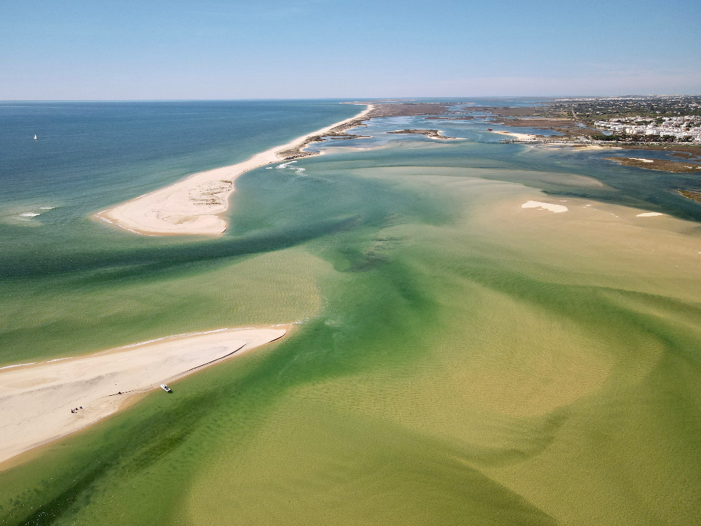 Aerial view of the Ria Formosa lagoon near Fuseta: sandbanks, shallow turquoise channels and the barrier island.